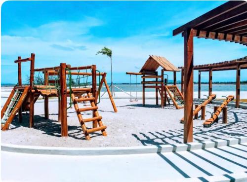 a group of wooden playground equipment on the beach at Golden Lake Experiência Inesquecível 6 apto 301 in Arraial do Cabo