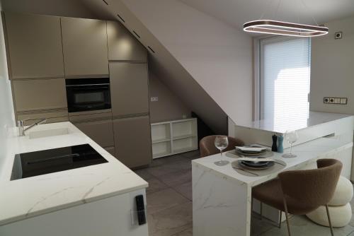 a kitchen with white cabinets and a table with chairs at Kleine Studio-Wohnung, kontaktloser Check-in in Meckenbeuren