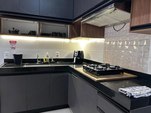 a kitchen with a stove and a counter top at Apartamento Black Confort in Franca