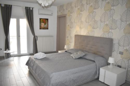 a bedroom with a bed and a wall with flowers at CASA della GIOIA in Caltagirone
