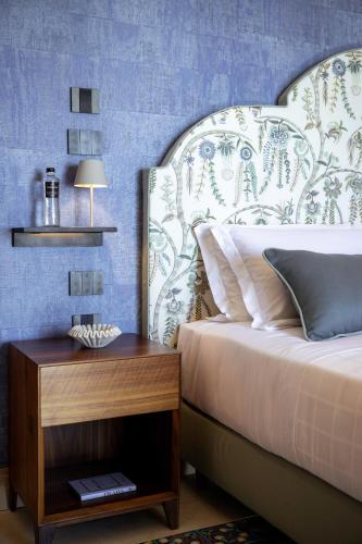 a bedroom with a bed and a nightstand next to a bed sidx sidx sidx at Antalia Boutique Hotel in Positano