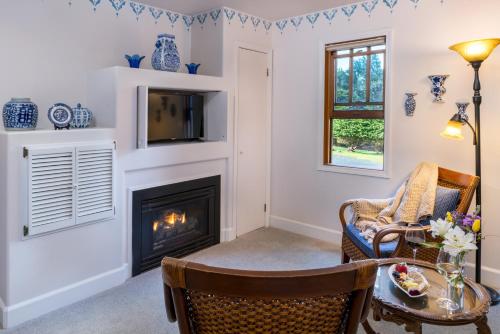 a living room with a fireplace and a table and chairs at Arch Cape Inn and Retreat in Arch Cape