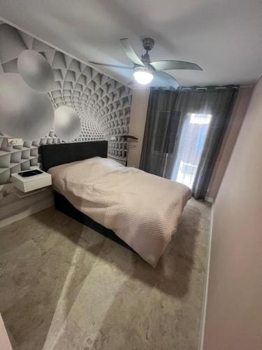 a bedroom with a bed and a ceiling fan at Playa Port aventura la pineda in La Pineda