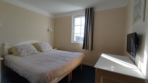 une petite chambre avec un lit et une télévision dans l'établissement Maison 6-8 pers - 3 chbres - mer - piscine - golf, à Talmont-Saint-Hilaire