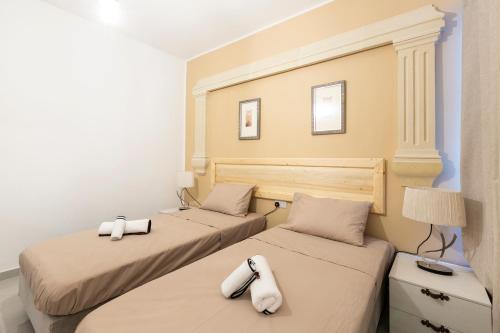 a bedroom with two beds with white pillows at Quiet Traditional Stay - Rabat 3-Bedroom Apartment in Ħal-Bajjada