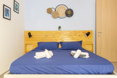 a blue bed with two white towels on it at Quiet Traditional Stay - Rabat 3-Bedroom Apartment in Ħal-Bajjada