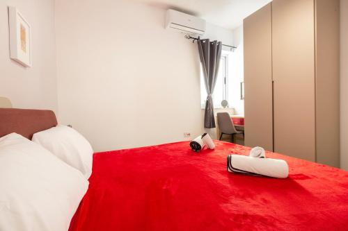 a bedroom with a red bed with two towels on it at Quiet Traditional Stay - Rabat 3-Bedroom Apartment in Ħal-Bajjada