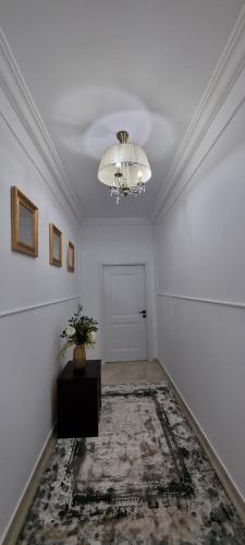 a white room with a chandelier on the ceiling at Studio 1 in Tîrgu Neamţ