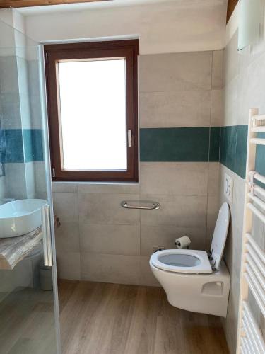 a bathroom with a toilet and a sink and a window at Agriturismo Casa del Principe in Torre Bormida