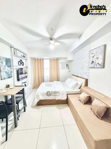 um quarto com uma cama e uma mesa em uma sala em Unit 33k studio em Cebu