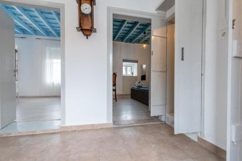 a hallway with white walls and a clock on the wall at Xenofon Traditional Rooms in Rhodes Town