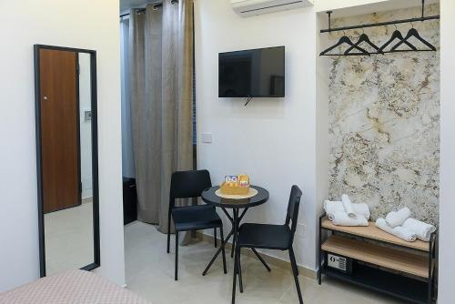 a room with a table and chairs and a television at Maison centro storico in Naples