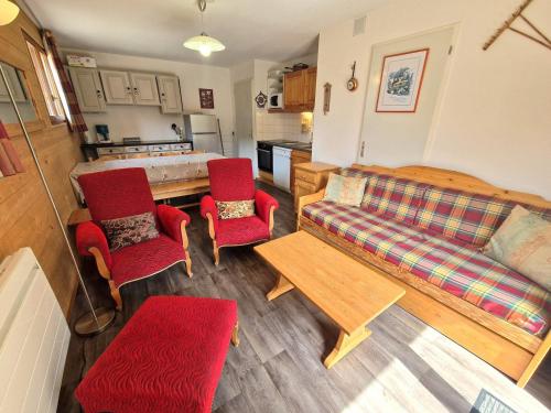 un salon avec un canapé et des chaises rouges dans l'établissement Appartement 4 pièces pour 6/8 personnes avec terrasse, proche pistes et centre à Valfréjus - FR-1-265-172, à Valfréjus