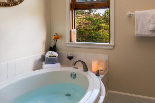 a bath tub in a bathroom with a window at Arch Cape Inn and Retreat in Arch Cape