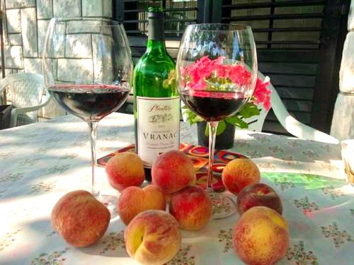 two glasses of wine sitting on a table with apples at Aparthotel Monterria in Bar