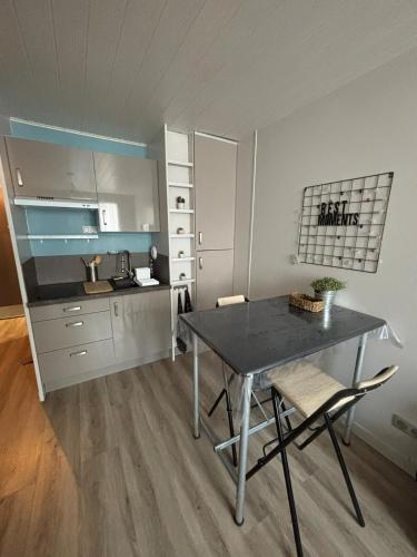 une cuisine avec une table et des chaises dans une pièce dans l'établissement Les Minimes La Rochelle Studio, à La Rochelle