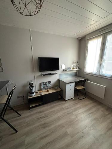 Il comprend un salon avec un bureau et une télévision à écran plat. dans l'établissement Les Minimes La Rochelle Studio, à La Rochelle