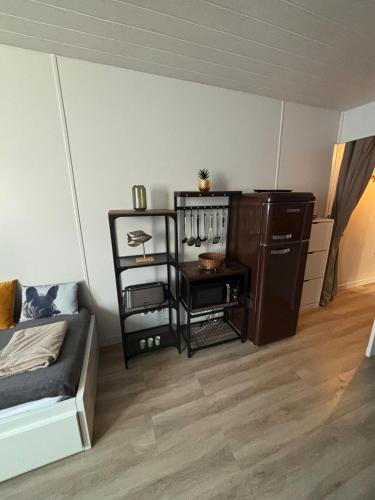Cette chambre comprend un lit et une table avec une étagère. dans l'établissement Les Minimes La Rochelle Studio, à La Rochelle