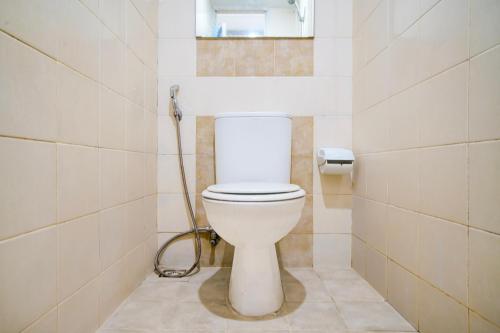 a bathroom with a toilet with a hose at Collection O Baros Near Stasiun Cimahi in Cimahi