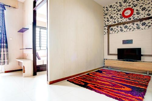 a living room with a television and a rug at Collection O Baros Near Stasiun Cimahi in Cimahi
