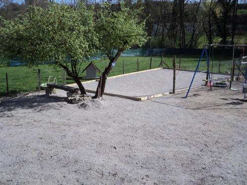 a park with a tree and a playground at Gîte La Lieutenance in Saint-Pourçain-sur-Sioule