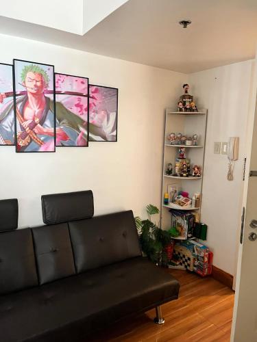 a living room with four paintings on the wall at Serenity Escapes by Aj in Manila