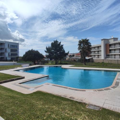 a large swimming pool in a park with buildings at Casa dos Medros in São Martinho do Porto
