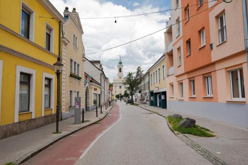 an empty street with buildings and a clock tower at Modernes Studio im Zentrum 4 Personen in Wiener Neustadt