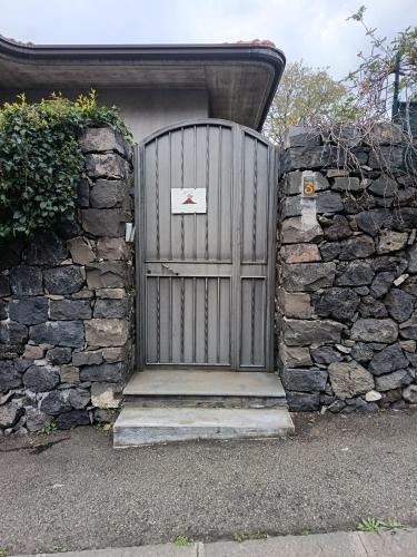 a gate in a stone wall with a sign on it at Mama Etna in Belpasso