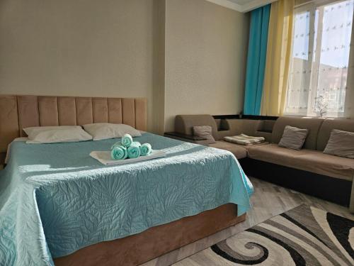 a bedroom with a bed with a couch and a table at ЖК Edel 1ком квартира комфорт набережная проспект Сарыарка in Astana