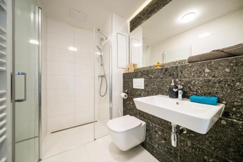 ブルノにあるAPARTIA apartments Brno centerのトイレ、洗面台、シャワー付きのバスルーム