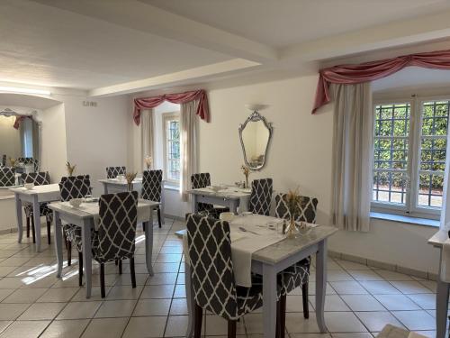 ein Esszimmer mit Tischen und Stühlen und einem Spiegel in der Unterkunft B&B Villa Agnese Lucca in Lucca