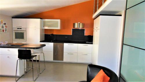 une cuisine avec des armoires blanches et une table et des chaises dans l'établissement Didalie locations cigale, à Sainte-Maxime