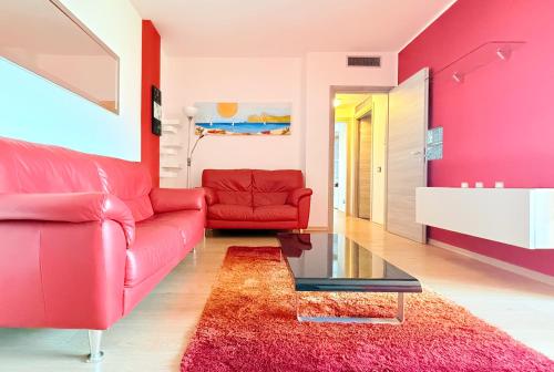 a living room with a red couch and a red chair at Da Elisa MareSol in Quartu SantʼElena