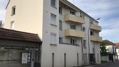 un bâtiment blanc avec des boîtes sur son côté dans l'établissement L'Anatole Wifi Parking, à Troyes