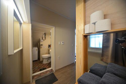 Camera dotata di bagno con servizi igienici e specchio. di Helloworld guesthouse a Seul