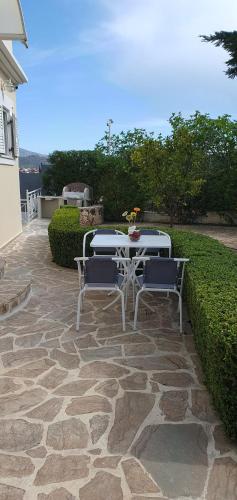 a table and two chairs on a stone patio at Jasmine Home, Aegina City in Egina
