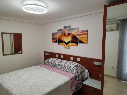 a bedroom with a bed and two paintings on the wall at Elche Stay 2, Amplio con garaje, 3 Dorms, 1 Baño in Elche