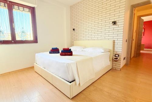 a white bed in a room with a brick wall at Da Elisa MareSol in Quartu SantʼElena