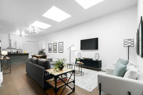 a living room with two couches and a kitchen at Modern and Cozy 2bdr near St-Hubert Plaza in Montréal