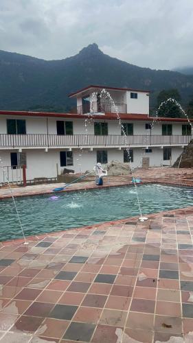 a house with a swimming pool in front of a building at Quinta Las Mendoza in Zetaquira
