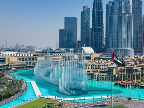 a large fountain in the middle of a city at GRANDE RESIDENCES with a direct Burj Khalifa view and Private Fountain Show at 14th floor with DXB AIRPORT VIP Shuttle in Dubai