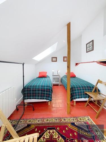 - une chambre avec 2 lits, une table et un tapis dans l'établissement Les Gîtes de La Chartreuse - Jaunay Marigny - 3mnFuturoscope, à Jaunay-Clan