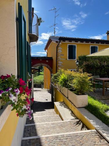 a walkway leading to a building with flowers on it at Relais Fontana Rosa B&B Wellness in Caprino Veronese