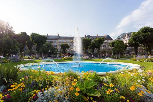 une fontaine au milieu d'un parc fleuri dans l'établissement Le Saint Jacques 