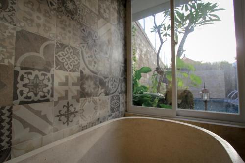 a bath tub in a bathroom with a window at Saka Luxury Villa in Jimbaran