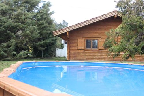 a blue swimming pool in front of a house at Beewood in Fiais
