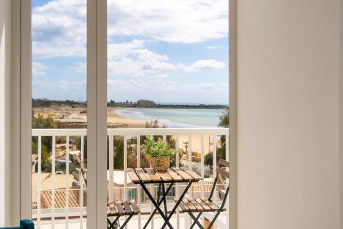 a balcony with a table and a view of the beach at Casa vacanze-Laguna Blu in Marina di Modica