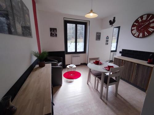 - un salon avec une table, des chaises et une horloge dans l'établissement Le Tartaret - Murol, à Murol