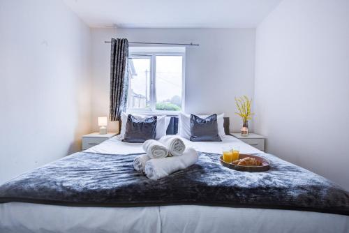 Una cama con toallas y un bol de fruta. en Spacious 2 Bed Apartment South London, en Thornton Heath